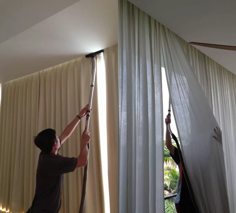 A man dusting and vacuuming curtains